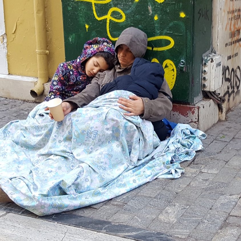 ATHENS, GREECE - JANUARY 18, 2019: Homeless beggars mother and childs sleeping on the road in Athens, Greece